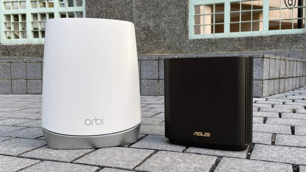 asus zenwifi ax vs netgear orbi router sitting together